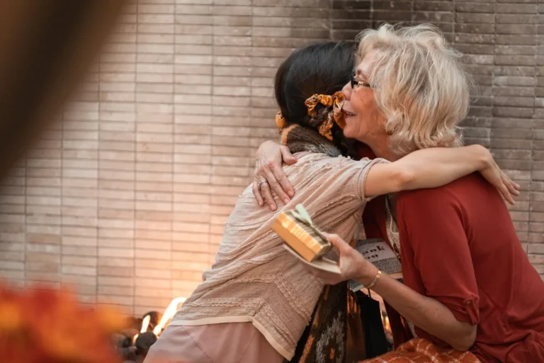 Two women hugging at a family visit