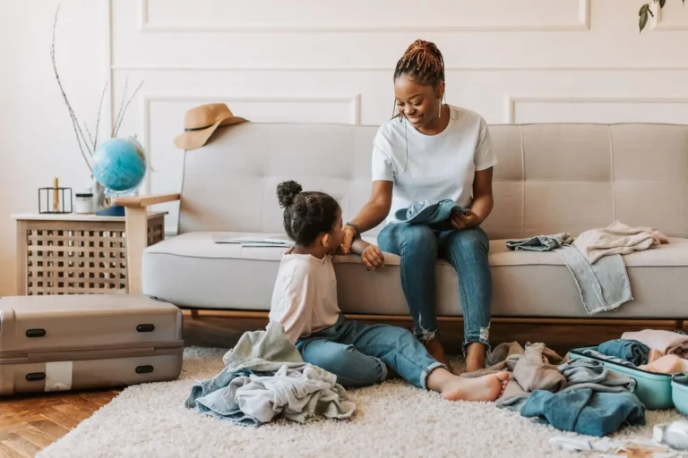 Mother and daughter packing clothes for a trip