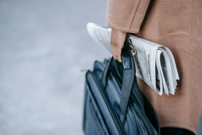 Commuter carrying a work bag and newspaper