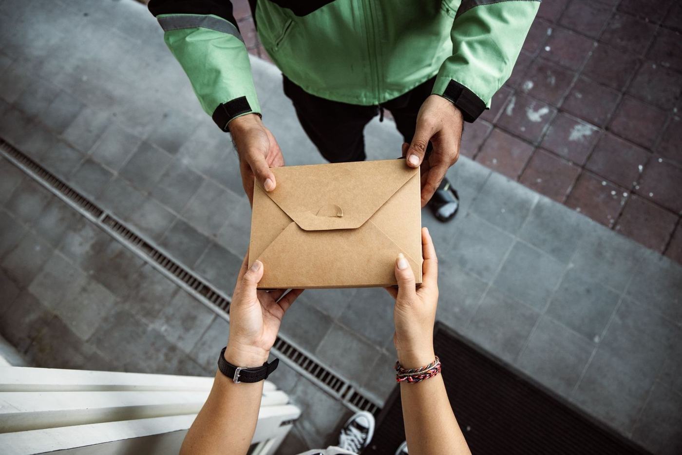 Two people passing a brown envelope from hand to hand