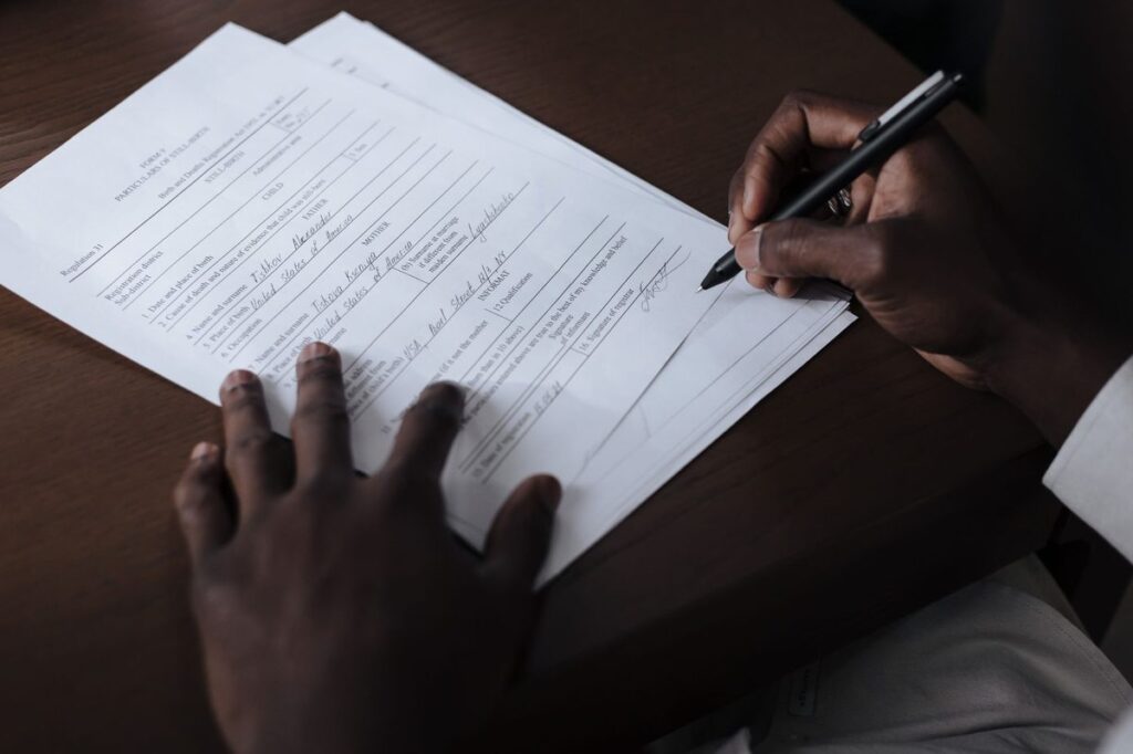 Man's hand signing a turnover declaration letter FTA UAE offices request, on a table