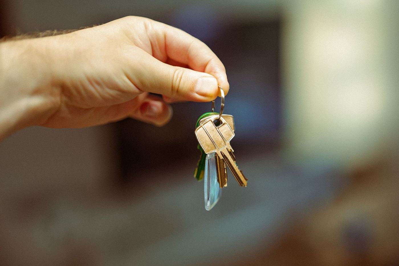 Hand holding out a set of house keys